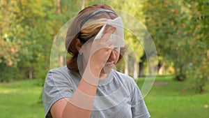 A young girl with allergies in an autumn park. Sneezing girl blows her nose into a napkin and sneezes. selective focus