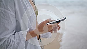 Young girl answering phone call on cloudy beach close up. Woman using telephone