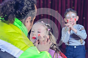 Young Girl Applied with Clown Makeup by an Artist