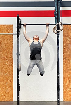 Young girl athlete doing pull-ups on a bar