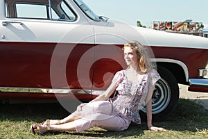 a young girl on the background of a retro car