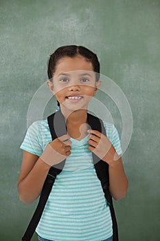 Young girl with bagpack against chalk board photo