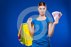 Young girl with bags and bunch of money in the hands of