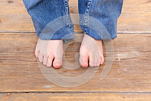 Young girl barefoot on wooden floor