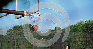 Young girl basketball player exercising on outdoor court.