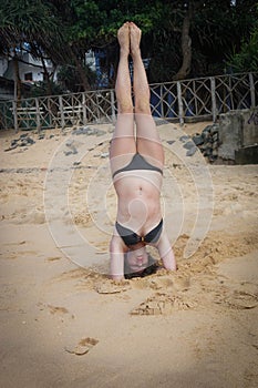 Young girl on the beach doing morning excercises