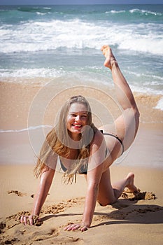 Young girl on the beach doing morning excercises