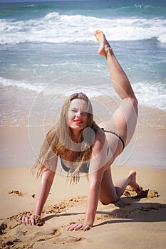 Young girl on the beach doing morning excercises