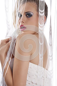 Young girl behind white curtain standing