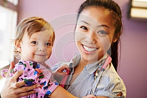 Young Girl Being Held By Female Pediatric Doctor