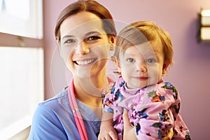 Young Girl Being Held By Female Pediatric Nurse