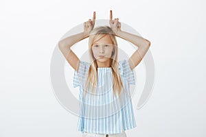 Young girl being stubborn, having no respect to adults. Portrait of indifferent confident cute daughter with blond hair