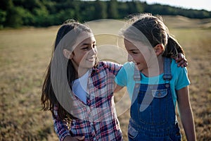 Young girl best friends spending time in nature, during sunset. Girls on walk, embracing.