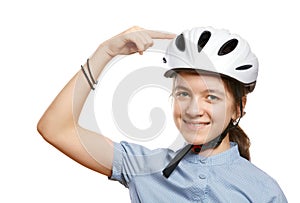 Young girl in a bicycle helmet points to a helmet, isolated on white.