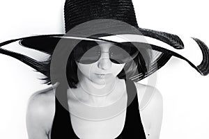 Young girl in a big round sunglasses and summer hat