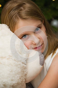 Young girl with a big white teddy bear toy