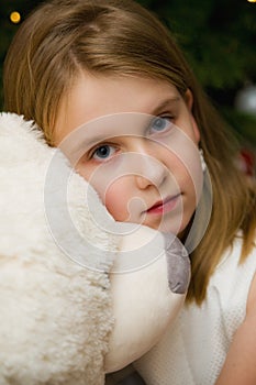 Young girl with a big white teddy bear toy