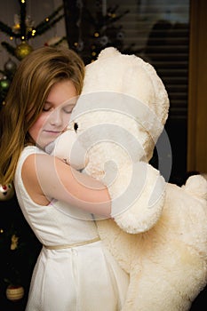 Young girl with a big white teddy bear toy