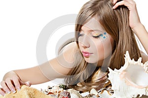 The young girl in bikini lays with seashells photo