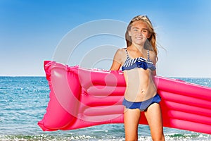 Young girl in bikini with pink inflatable mattress photo
