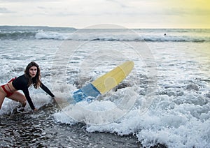 Young girl in bikini - surfer with surf board dive underwater with fun under big ocean wave. Family lifestyle, people