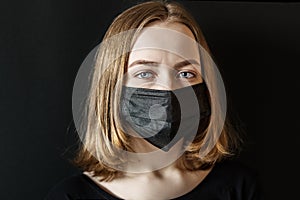 Young girl in a black protective three-layer facial surgical mask. The concept of life in the coronavirus pandemic and after. The