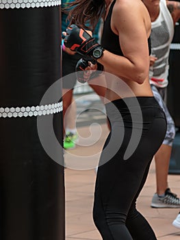 Young Girl in Black Sportswear: Fitness Boxing Workout with Punching Bag