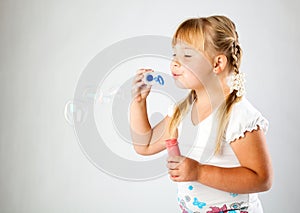 Young girl blow out soap bubbles