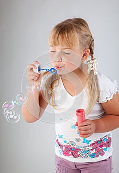 Young girl blow out soap bubbles