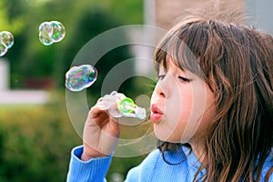 Young girl blowing bubbles