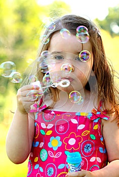 Young girl blowing bubbles