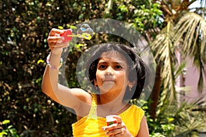 Young girl blowing bubbles