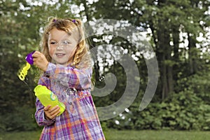 Young girl blowing soap bubbles