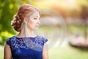 Young girl in blue lace dress looking straight