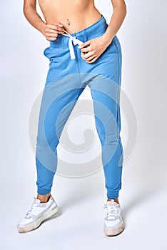 A young girl in blue sweatpants on a white background