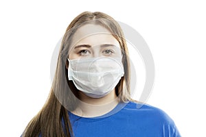 A young girl in a blue T-shirt in a medical mask on her face. Precautions during the coronavirus pandemic. Isolated on a white