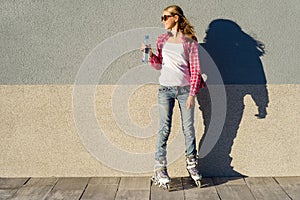 Young girl with a bottle of water, shod in rollers.