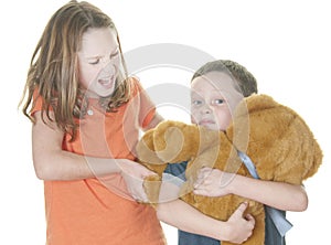 Young girl and boy fighting over bear photo