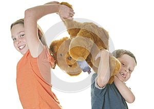 Young girl and boy fighting over bear