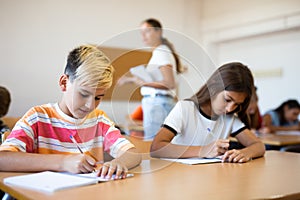 Young girl and boy studying subject in classroom