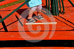 Young girl braces on an old merry-go-round.