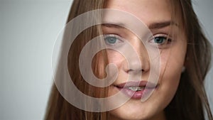 Young girl with braces on teeth throws back her head and appears in the frame.