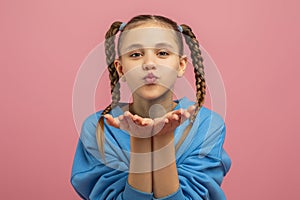 Young Girl With Braided Pigtails Blowing a Kiss