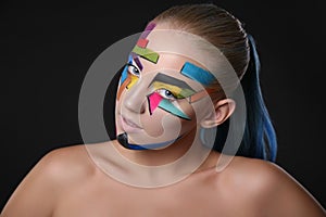 Young girl with bright geometric pattern on her face.Halloween style photo
