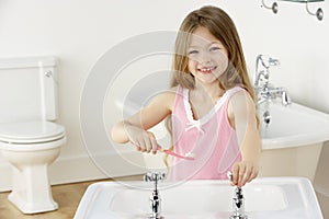 Young Girl Brushing Teeth at Sink