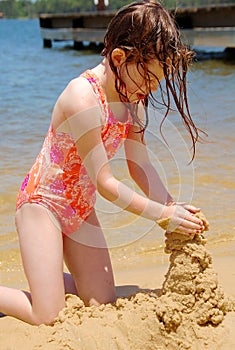 Young Girl Building Sand Castle