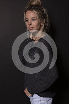 Young girl with bunched hair posing for photoshoot on black background