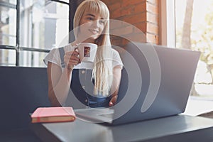 Young girl at cafe drinking coffee and using mobile phone. Online shopping