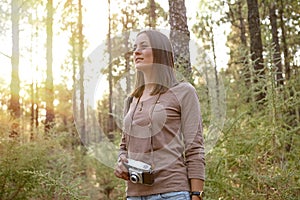 Young girl with camera in the woods