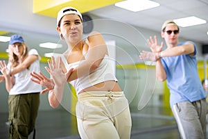 Young girl in cap training breakdance Toprock moves in dance hall